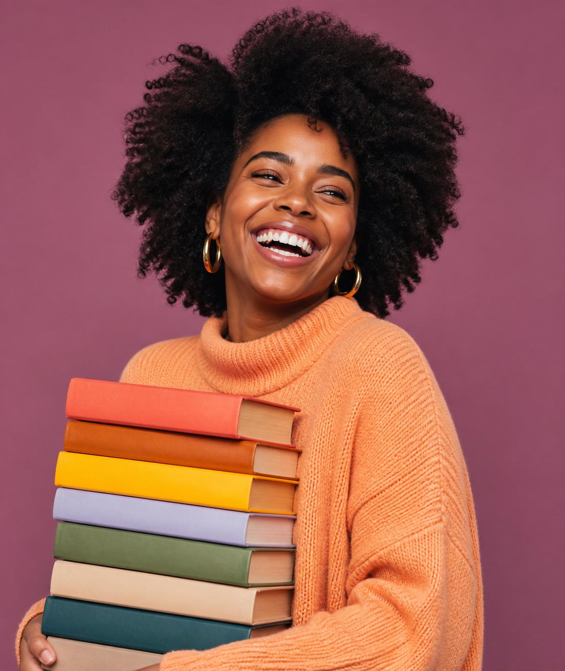 Jeune personne noire souriante tenant une pile de livres colorés